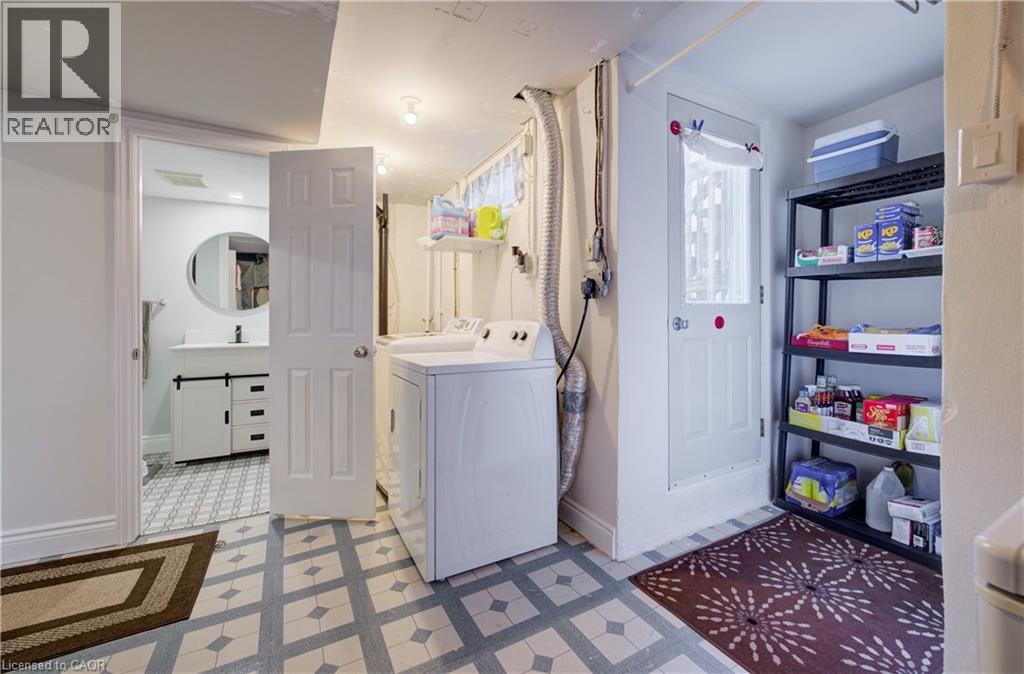 Laundry area featuring patterned tile flooring, a washer, and a storage rack - 172 Rennie Drive, Kitchener, ON - Indoor Photo Showing Laundry Room