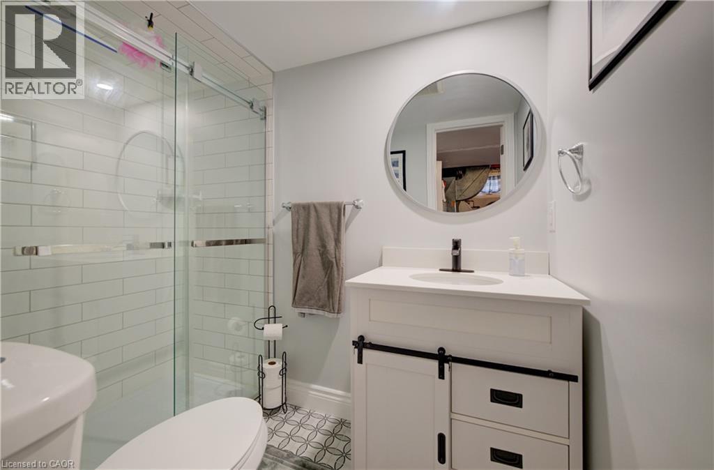 Glass-enclosed shower with subway tile surround and a circular accent detail - 172 Rennie Drive, Kitchener, ON - Indoor Photo Showing Bathroom