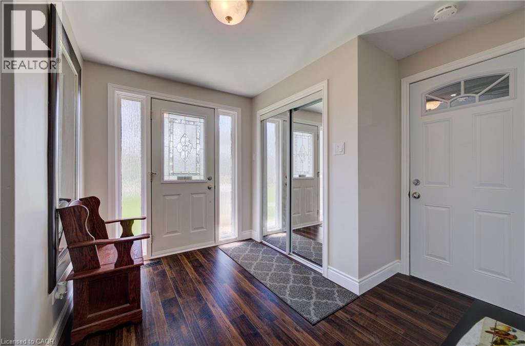 Front entry featuring a decorative glass door with sidelights, wood-finish flooring, and a mirrored sliding closet - 172 Rennie Drive, Kitchener, ON - Indoor Photo Showing Other Room