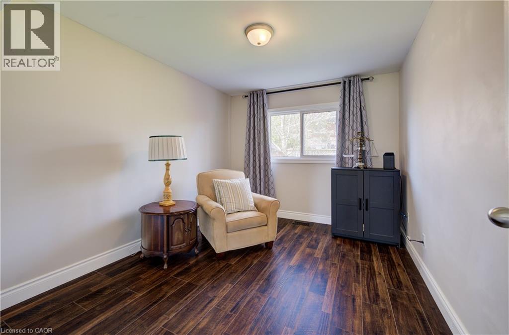 Interior room featuring dark wood-finish flooring, white baseboards, and neutral wall paint - 172 Rennie Drive, Kitchener, ON - Indoor