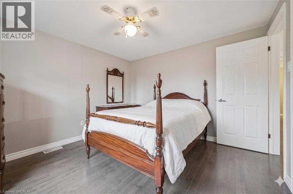 Upper-level landing featuring wood-finish flooring, a traditional wood staircase, a modern spherical chandelier, white trim, and multiple doorways - 42 Trailview Drive, Kitchener, ON - Indoor Photo Showing Other Room
