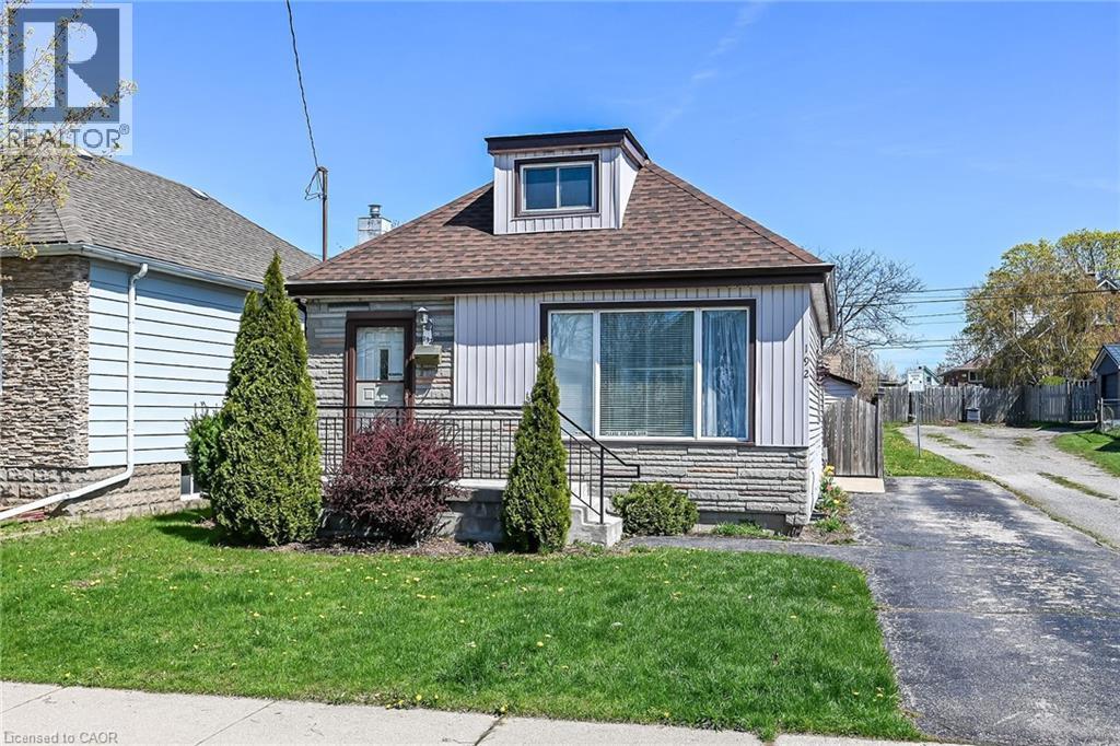 Front exterior with light-colored siding and a stone veneer foundation - 192 Ivon Avenue, Hamilton, ON - Outdoor