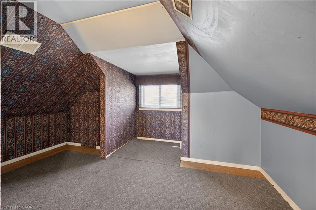 Attic space with sloped ceilings and patterned wallpaper - 192 Ivon Avenue, Hamilton, ON - Indoor Photo Showing Other Room