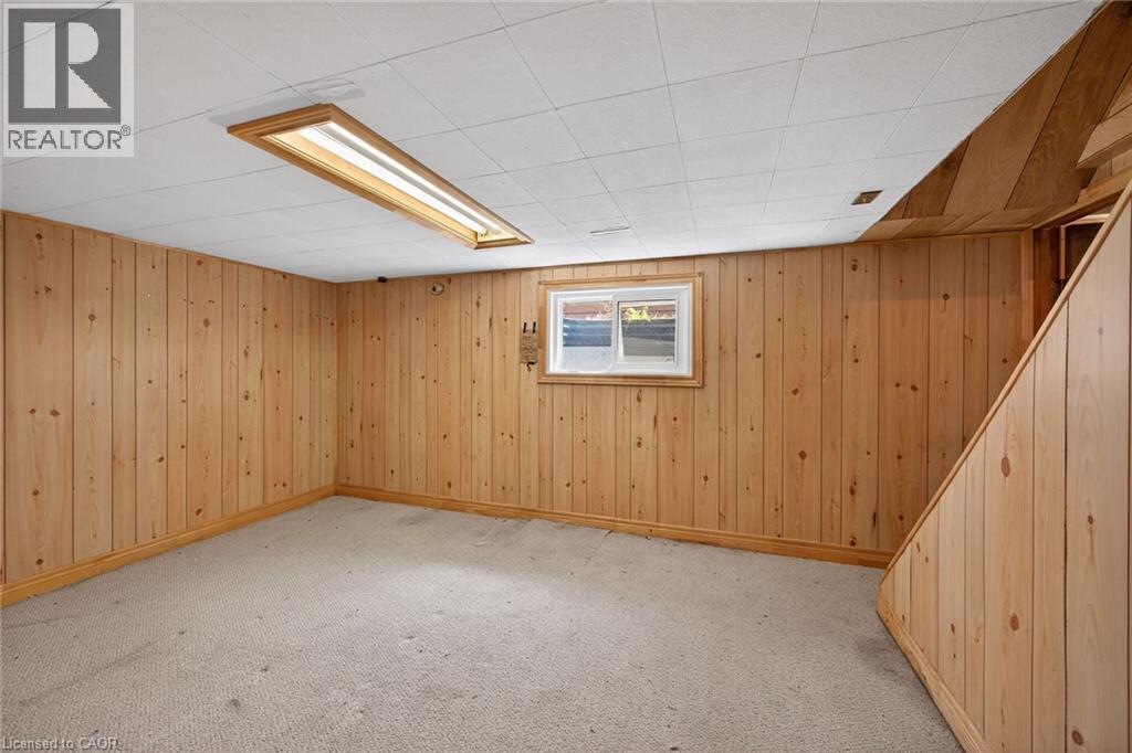Lower level room featuring wood-paneled walls, a drop ceiling with recessed lighting, and light-toned carpeting - 192 Ivon Avenue, Hamilton, ON - Indoor