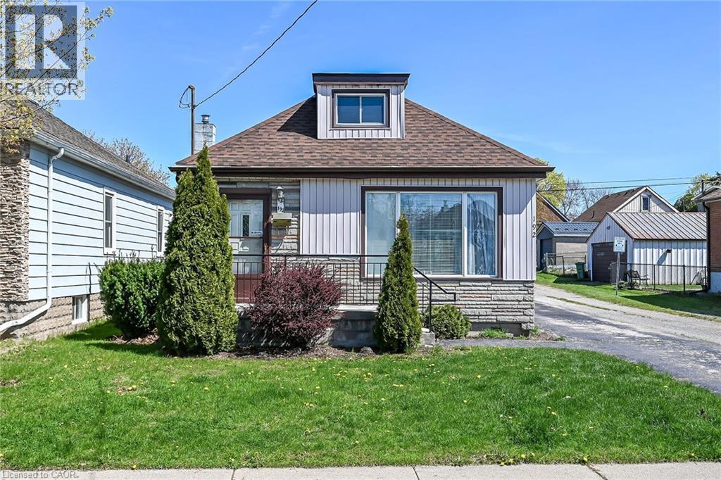 Front exterior featuring vertical siding, stone accents, a dormer window, and a gabled roof - 192 Ivon Avenue, Hamilton, ON - Outdoor