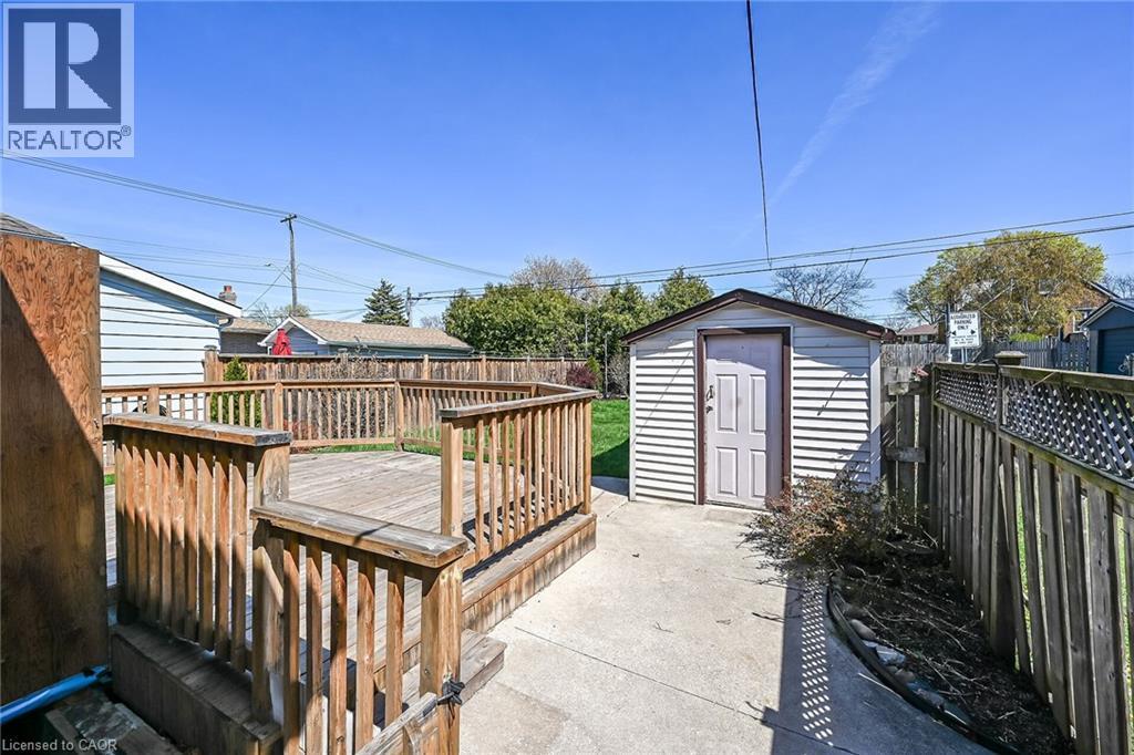 Spacious outdoor deck with wood railings, a dedicated concrete patio area, and a functional storage shed - 192 Ivon Avenue, Hamilton, ON - Outdoor With Deck Patio Veranda With Exterior