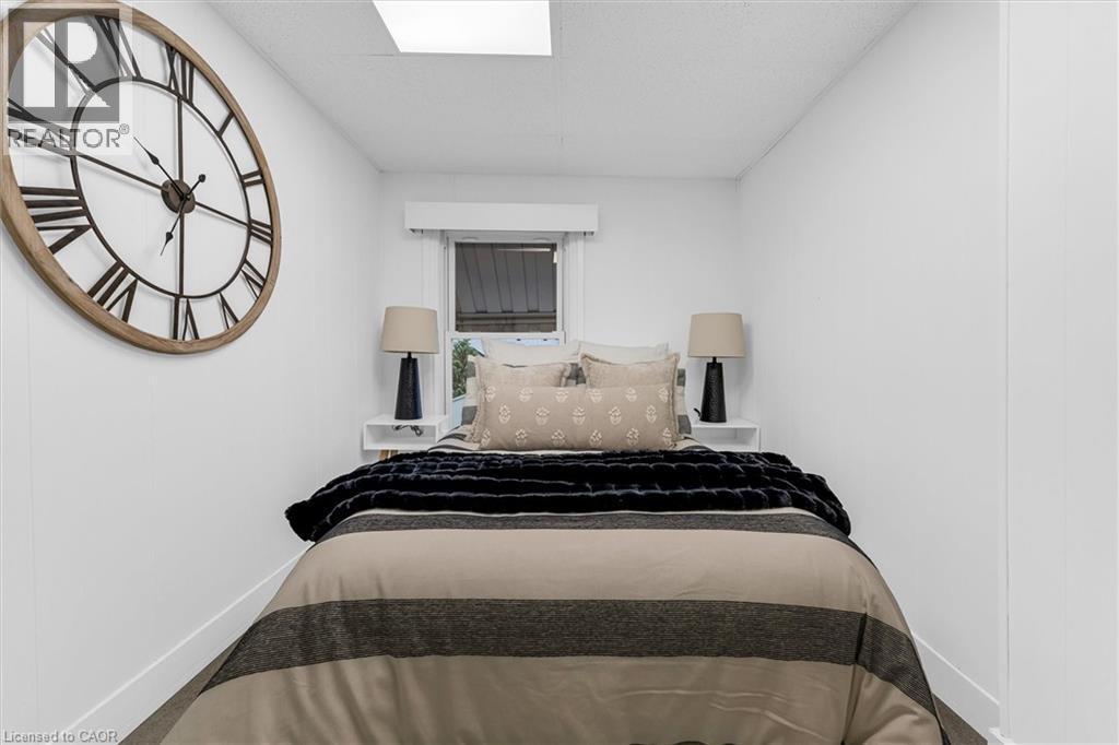 Compact bedroom featuring a window, built-in shelving, and recessed ceiling lighting - 11 Ford Street, Hamilton, ON - Indoor Photo Showing Bedroom
