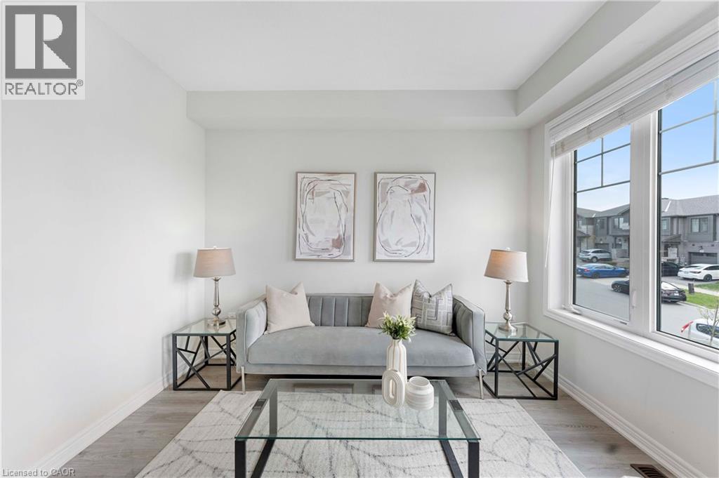 Bright living area featuring large windows with white trim, wood-finish flooring, and crisp white walls - 50 Hollywood Court, Cambridge, ON - Indoor Photo Showing Living Room
