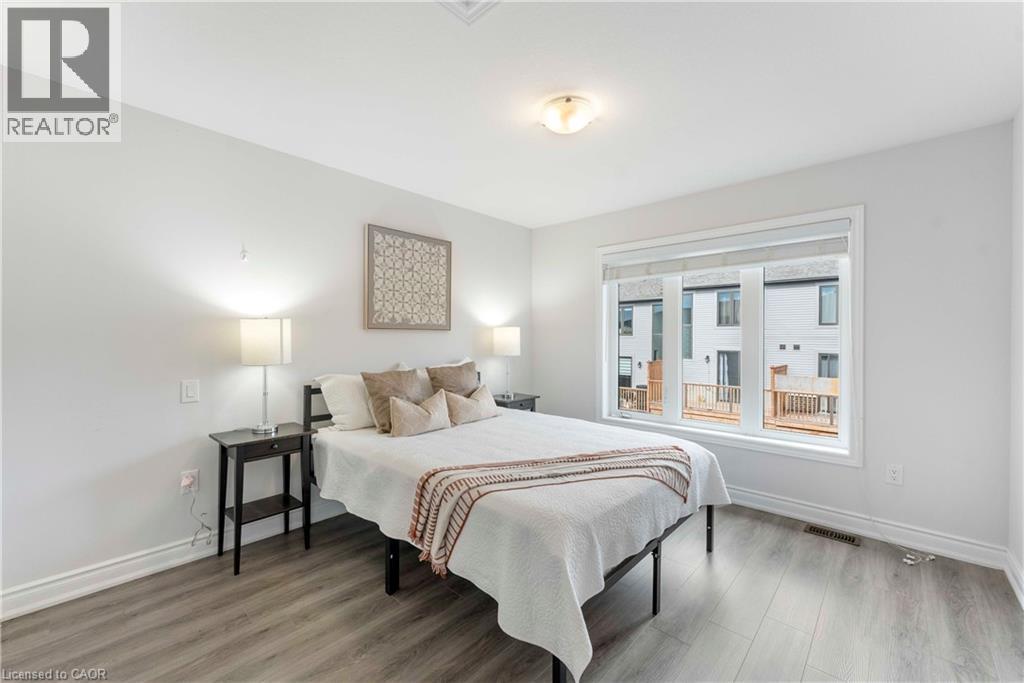 Bright room featuring a large window, neutral wall paint, and wood-finish flooring - 50 Hollywood Court, Cambridge, ON - Indoor Photo Showing Bedroom