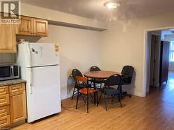 Kitchen area featuring wood-finish flooring, light wood cabinetry, and a light-colored countertop -