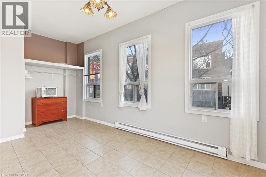 Bright interior space featuring light-toned tile flooring and multiple windows - 238-242 King Street E, Hamilton, ON