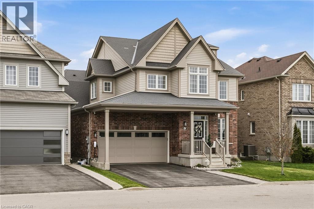 Two-story residence featuring brick and siding facade, covered front porch, and an attached two-car garage - 42 Yager Drive, Binbrook, ON - Outdoor With Facade