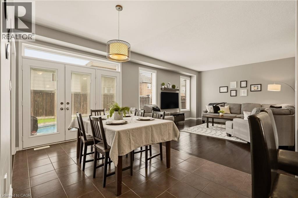 Open-concept living space featuring contrasting tile and wood-finish flooring - 42 Yager Drive, Binbrook, ON - Indoor Photo Showing Dining Room