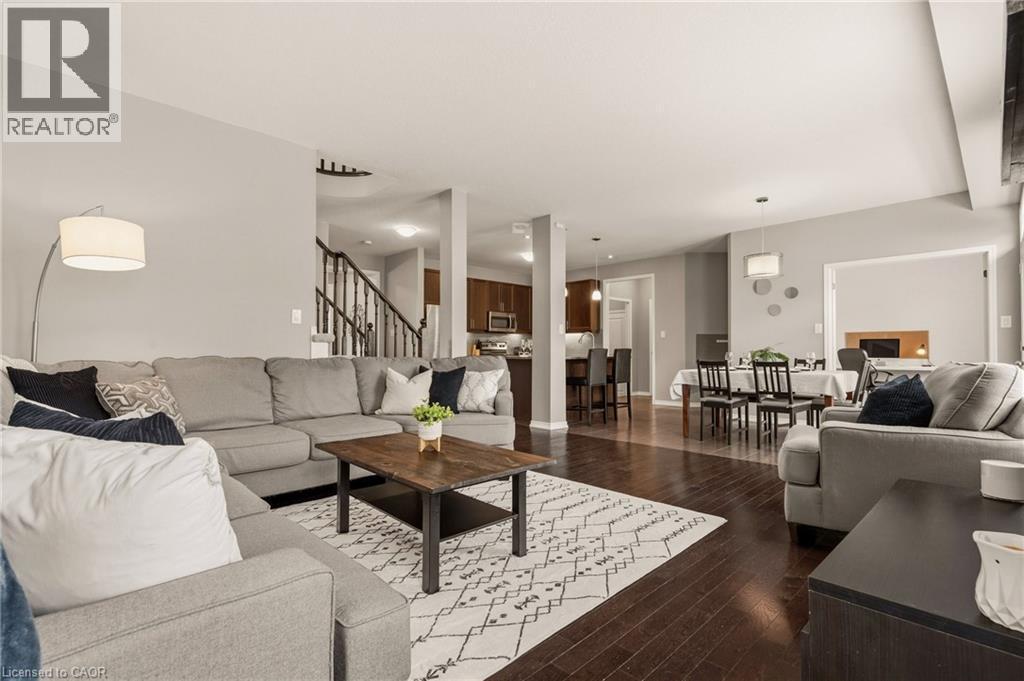 Expansive living area featuring rich wood-finish flooring, recessed lighting, and light gray wall tones - 42 Yager Drive, Binbrook, ON - Indoor Photo Showing Living Room