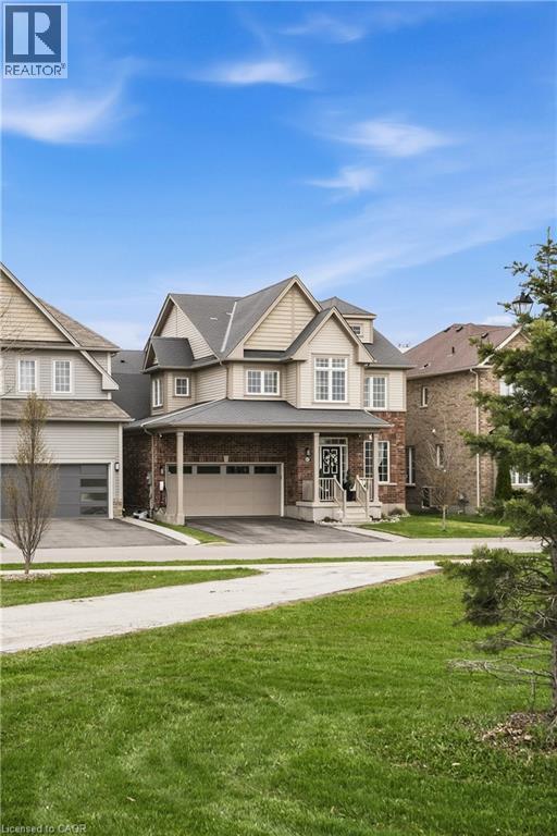 Two-story residence featuring a combination of brick and siding, a covered porch entrance, and an attached two-car garage - 42 Yager Drive, Binbrook, ON - Outdoor With Facade