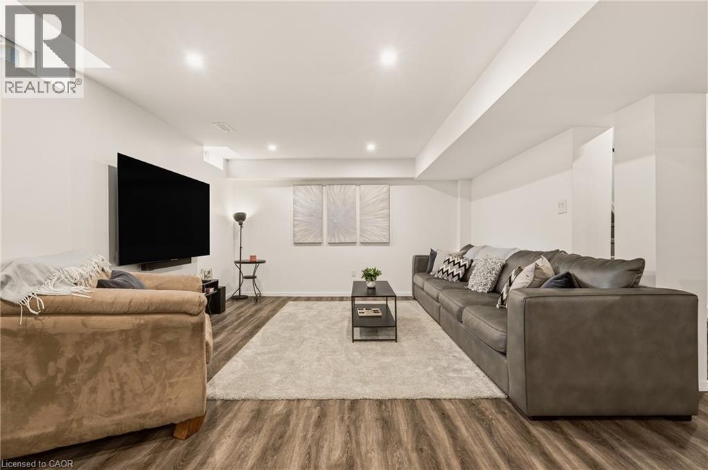Spacious entertainment area featuring wood-finish flooring, recessed lighting, and crisp white walls - 42 Yager Drive, Binbrook, ON - Indoor Photo Showing Living Room