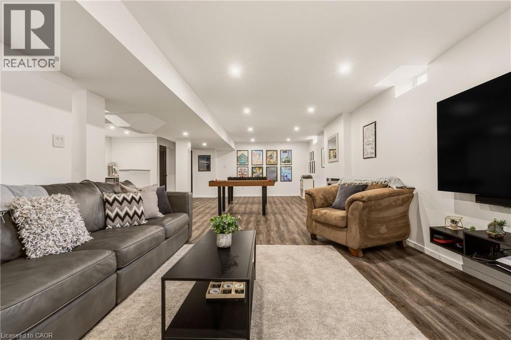 Expansive recreation room featuring wood-finish flooring, recessed lighting, and white painted walls - 42 Yager Drive, Binbrook, ON - Indoor Photo Showing Living Room