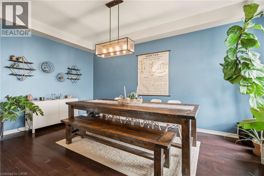 Dining area featuring wood-finish flooring, a contemporary rectangular light fixture, and a white built-in console cabinet - 42 Yager Drive, Binbrook, ON - Indoor