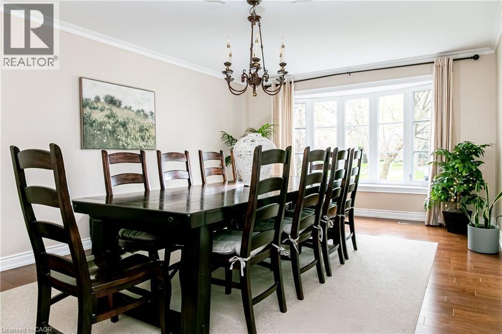 Formal dining area featuring a bay window with ample natural light, crown molding, and wood-finish flooring - 1577 Old Spar Court, Mississauga, ON - Indoor Photo Showing Dining Room