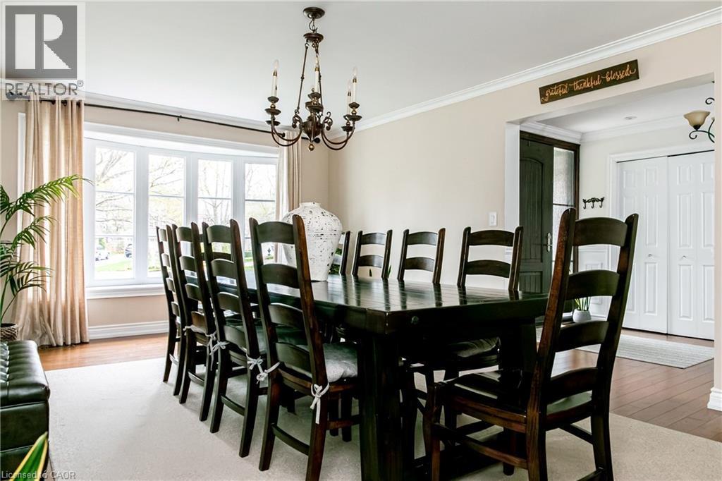 Spacious dining area featuring a bay window, hardwood flooring, and a decorative chandelier - 1577 Old Spar Court, Mississauga, ON - Indoor Photo Showing Dining Room