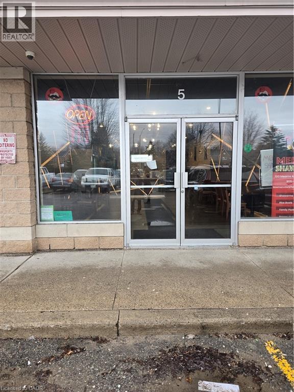 Commercial storefront featuring a glass entry door with a transom, large display windows, and a brick facade - 100 Mearns Avenue Unit# 5, Clarington, ON