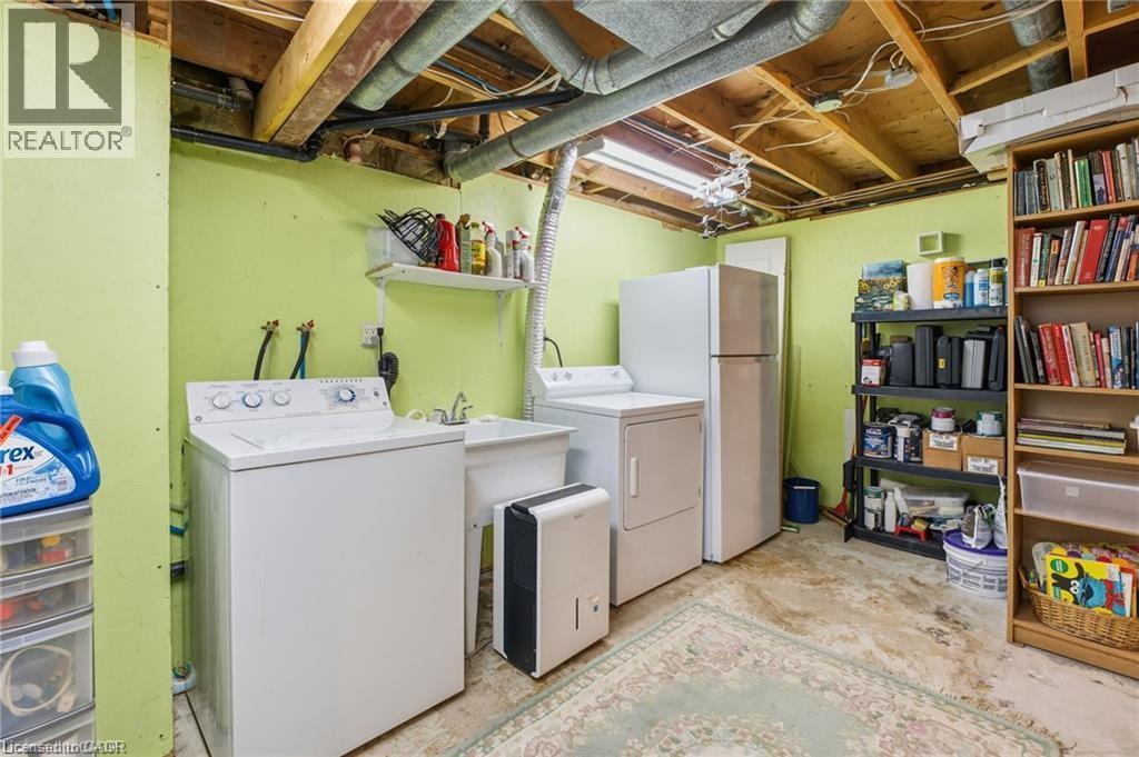 Laundry area featuring washing machine and clothes dryer, as well as large storage room - 668 Tomahawk Crescent, Ancaster, ON - Indoor Photo Showing Laundry Room
