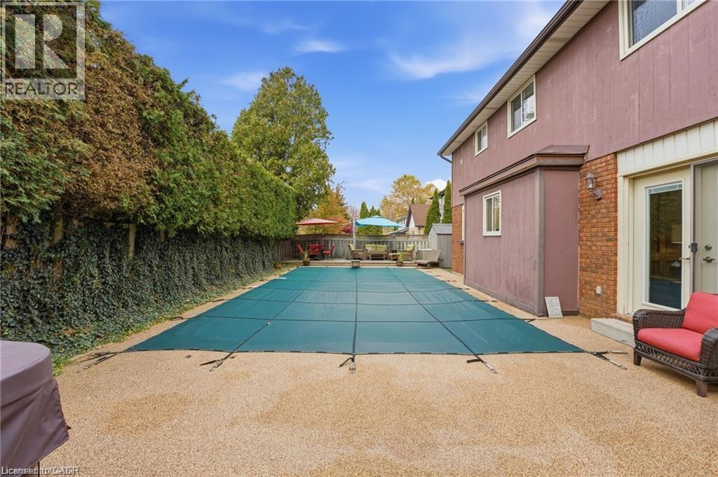 View of pool with winter elephant cover - 668 Tomahawk Crescent, Ancaster, ON - Outdoor With In Ground Pool