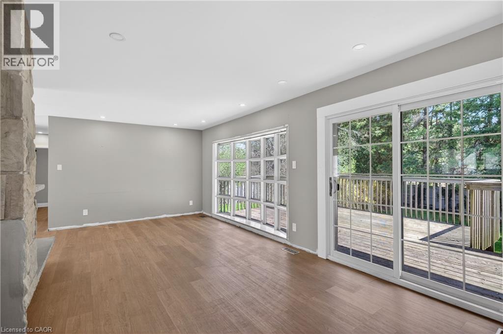 Spacious interior featuring wood-finish flooring, recessed lighting, and a stone fireplace surround - 515 Bobbybrook Drive, London, ON - Indoor