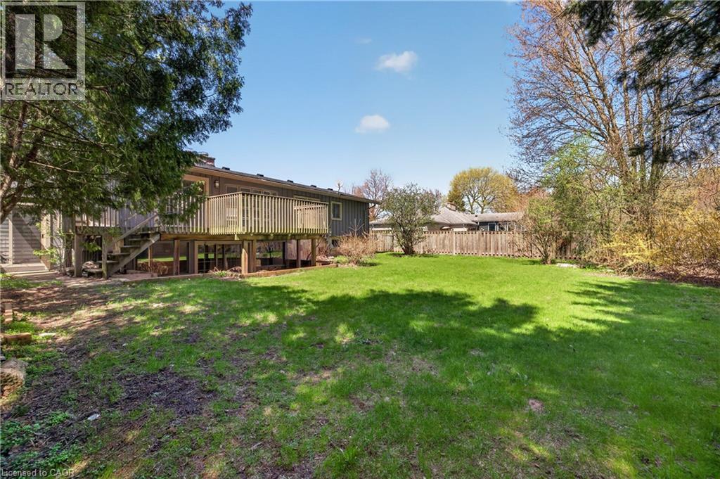 Expansive backyard featuring a manicured lawn, mature trees, and a wooden privacy fence - 515 Bobbybrook Drive, London, ON - Outdoor