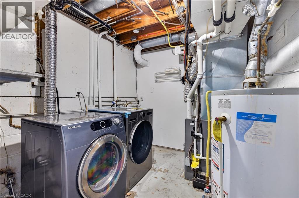 Utility area featuring exposed overhead plumbing, a water heater, and a concrete floor - 515 Bobbybrook Drive, London, ON - Indoor Photo Showing Laundry Room