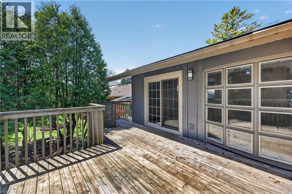 Expansive outdoor deck featuring wood flooring and railings, a sliding glass door, and a multi-pane fixed window - 515 Bobbybrook Drive, London, ON - Outdoor With Deck Patio Veranda With Exterior