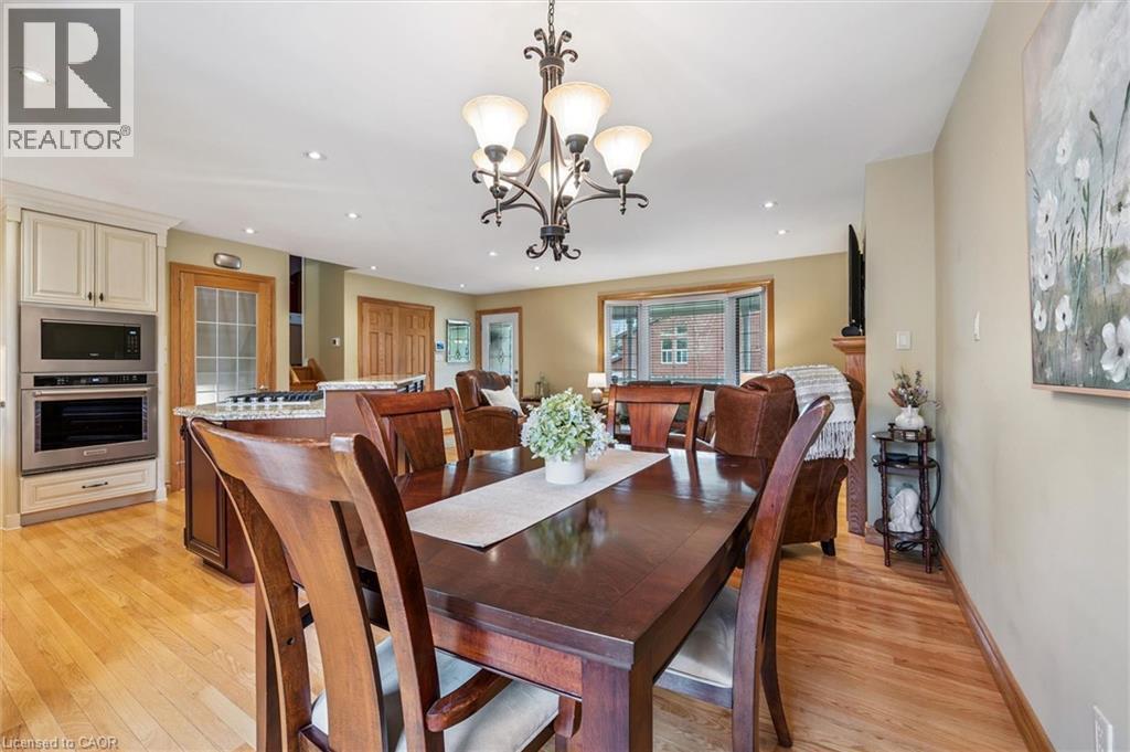Open-concept dining area featuring a wood-finish dining table and chairs, recessed lighting, and a decorative chandelier - 574 Sprucehill Avenue, Waterloo, ON - Indoor Photo Showing Dining Room