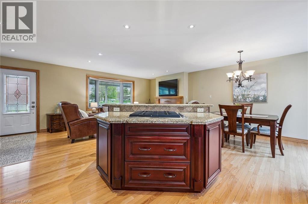 Kitchen island with granite countertop, integrated cooktop, and rich wood cabinetry - 574 Sprucehill Avenue, Waterloo, ON - Indoor