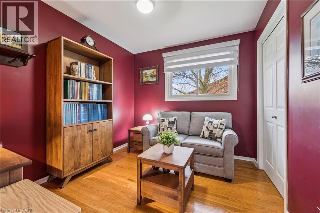 Inviting room featuring rich wall color, wood-finish flooring, and a bright window with a roller shade - 574 Sprucehill Avenue, Waterloo, ON - Indoor