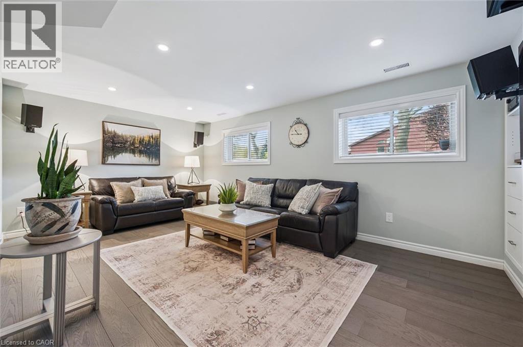 Spacious living area featuring wood-finish flooring, recessed lighting, and multiple windows with blinds - 574 Sprucehill Avenue, Waterloo, ON - Indoor Photo Showing Living Room