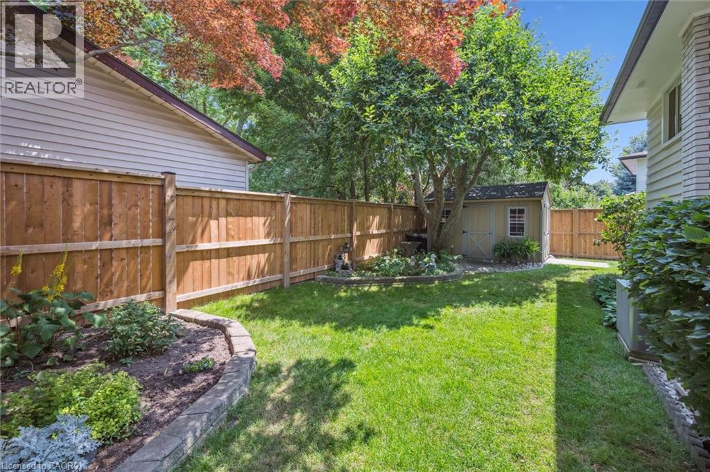 Expansive rear yard featuring a manicured lawn, established landscaping, and mature trees - 574 Sprucehill Avenue, Waterloo, ON - Outdoor