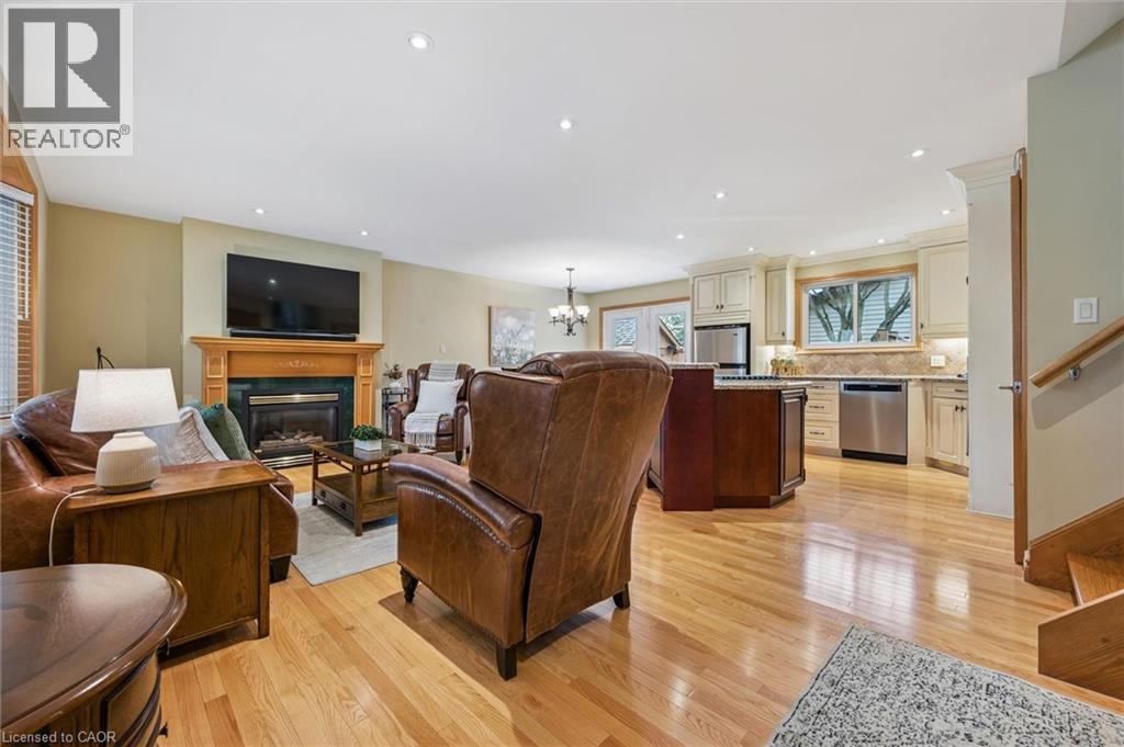 Open-concept living space featuring wood-finish flooring, recessed lighting, and a fireplace with a wood mantle - 574 Sprucehill Avenue, Waterloo, ON - Indoor Photo Showing Other Room With Fireplace