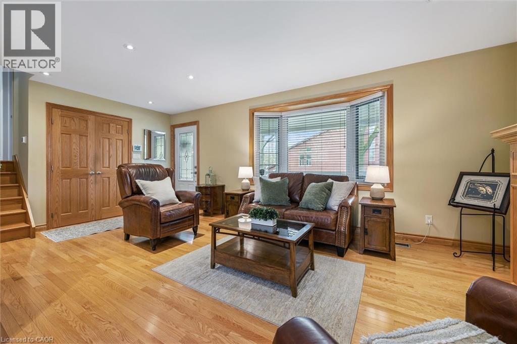 Spacious living area featuring wood-finish flooring, a bay window with blinds, and recessed lighting - 574 Sprucehill Avenue, Waterloo, ON - Indoor Photo Showing Living Room