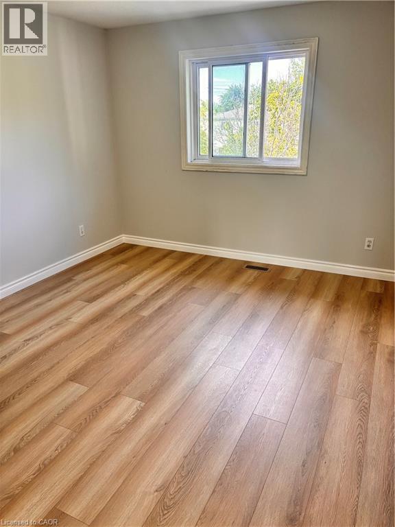 Bright interior space featuring wood-finish flooring, light-toned walls, and white trim - 206 Northmanor Crescent, Kitchener, ON