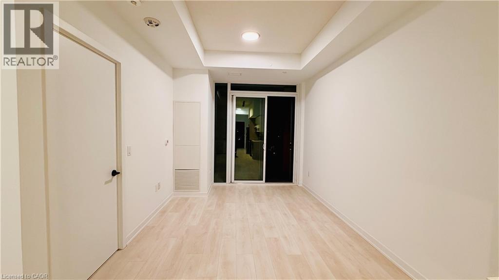 Open living space featuring light wood-finish flooring, recessed ceiling lighting, and a sliding glass door - 4878 Powers Common Unit# 301, Burlington, ON - Indoor Photo Showing Other Room