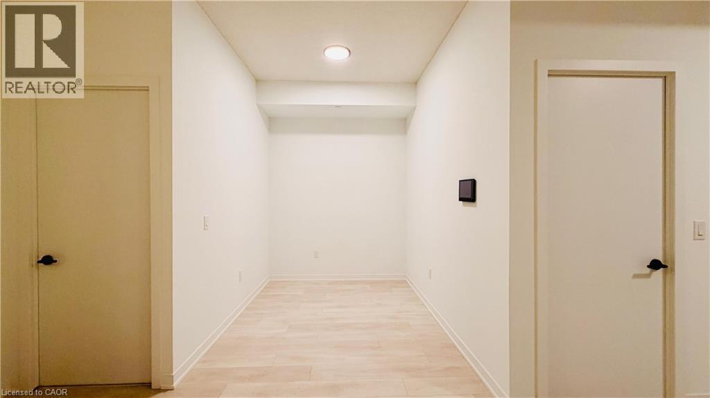 Hallway featuring light wood-finish flooring, white walls, and recessed lighting - 4878 Powers Common Unit# 301, Burlington, ON - Indoor Photo Showing Other Room
