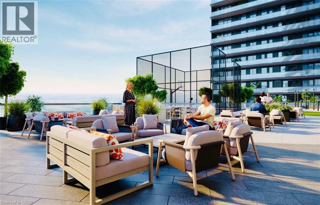Spacious rooftop patio featuring multiple lounge seating areas, a paved surface, perimeter landscaping, and an adjacent multi-sport court - 4878 Powers Common Unit# 301, Burlington, ON - Outdoor
