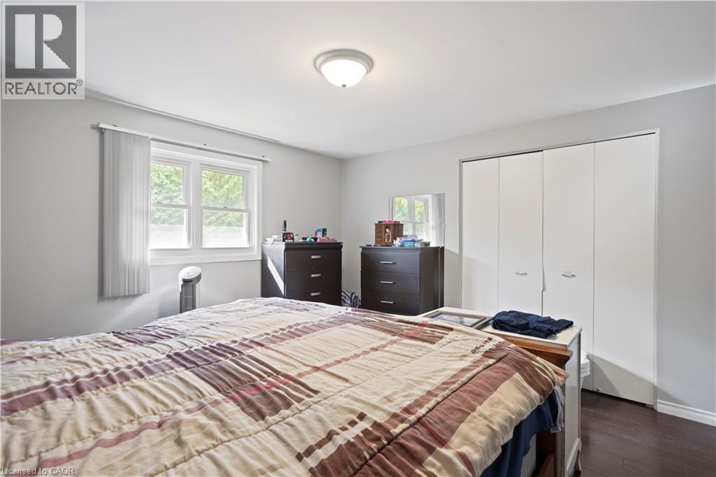 Bright room with a window providing outdoor views, featuring wood-finish flooring and a ceiling-mounted light fixture - 179 Vancouver Street, London, ON - Indoor Photo Showing Bedroom
