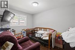 Interior room featuring wood-finish flooring, light gray wall paint, and a ceiling-mounted light fixture -