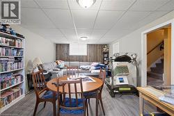 Finished lower level featuring wood-finish flooring, recessed lighting, and a partial wood-paneled accent wall -