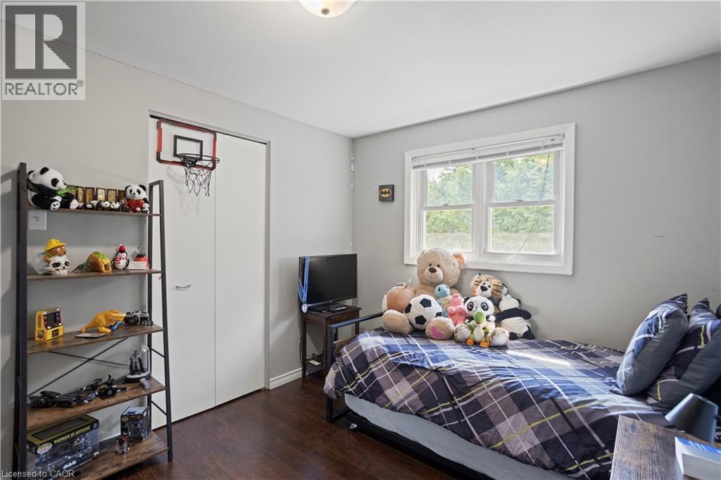 Room featuring wood-finish flooring, light grey walls, and a white-framed window - 179 Vancouver Street, London, ON - Indoor Photo Showing Bedroom