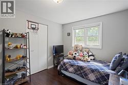 Room featuring wood-finish flooring, light grey walls, and a white-framed window -