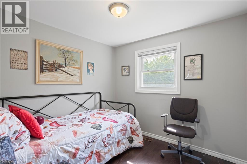 Bedroom featuring light gray walls, dark wood-finish flooring, a white trim window, and a flush mount ceiling light - 179 Vancouver Street, London, ON - Indoor Photo Showing Bedroom
