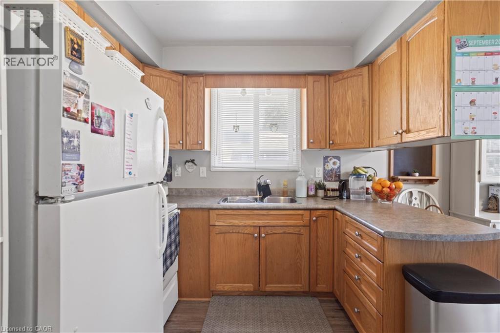 Kitchen featuring wood-finish cabinetry and a window above the sink - 179 Vancouver Street, London, ON - Indoor Photo Showing Kitchen With Double Sink