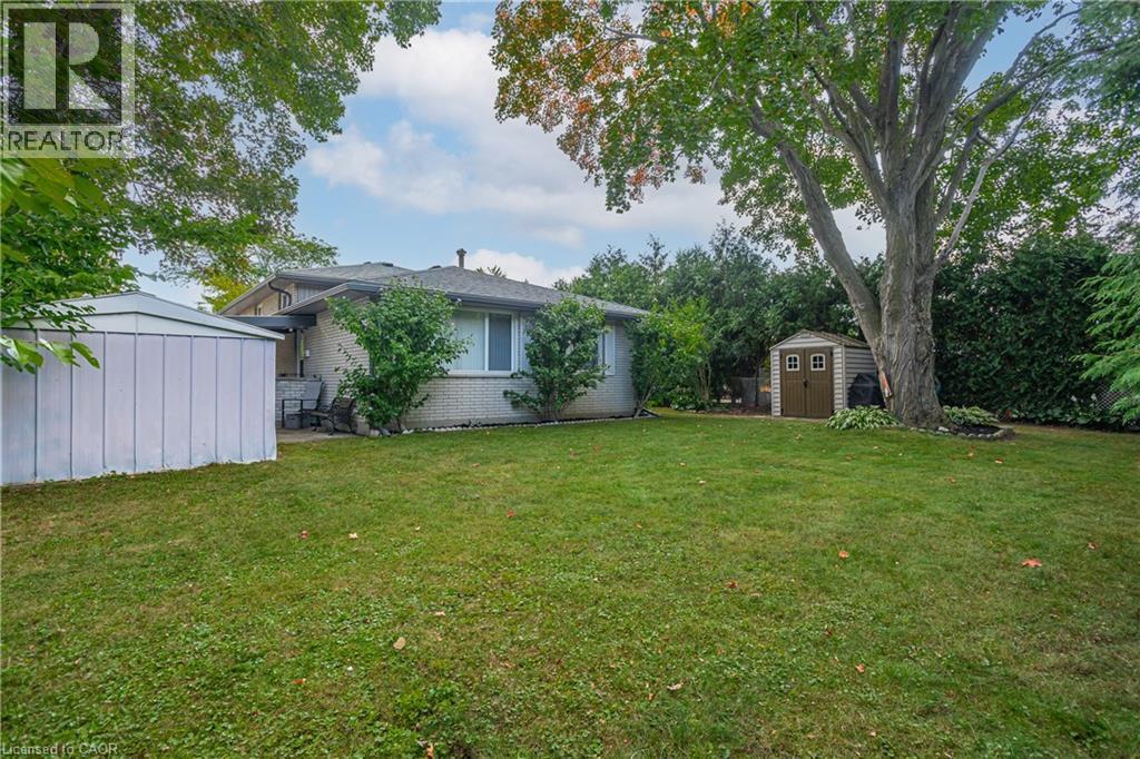 Spacious backyard featuring a manicured lawn, established trees, and two storage sheds - 179 Vancouver Street, London, ON - Outdoor
